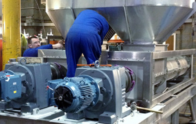 Fitters assembling a stainless steel screw press with geared motors
