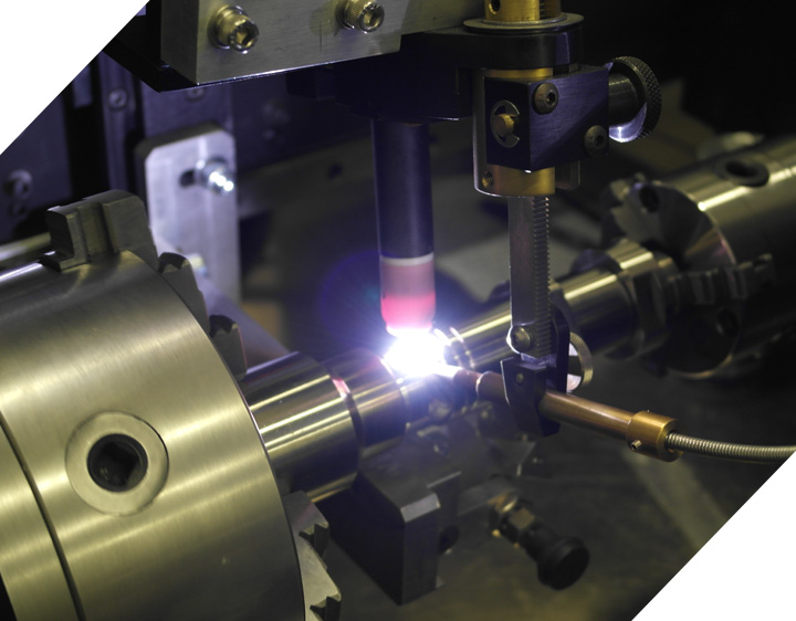 TIG torch welding a rotating component on a welding lathe